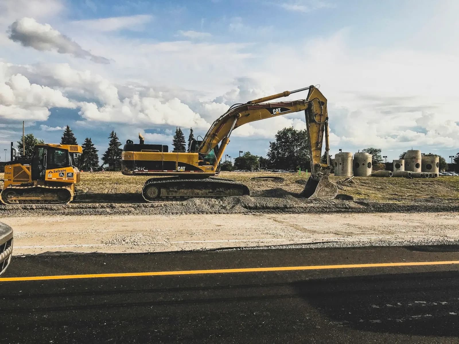 Excavator carrying out road construction and resurfacing work
