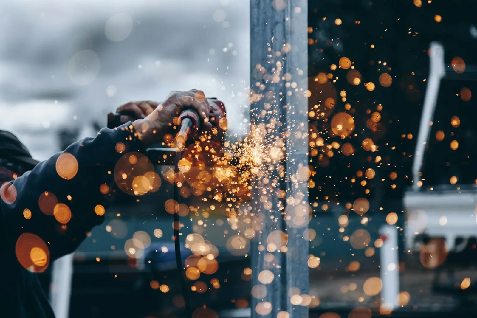 Close-up of metal grinding work with sparks flying at a fabrication site