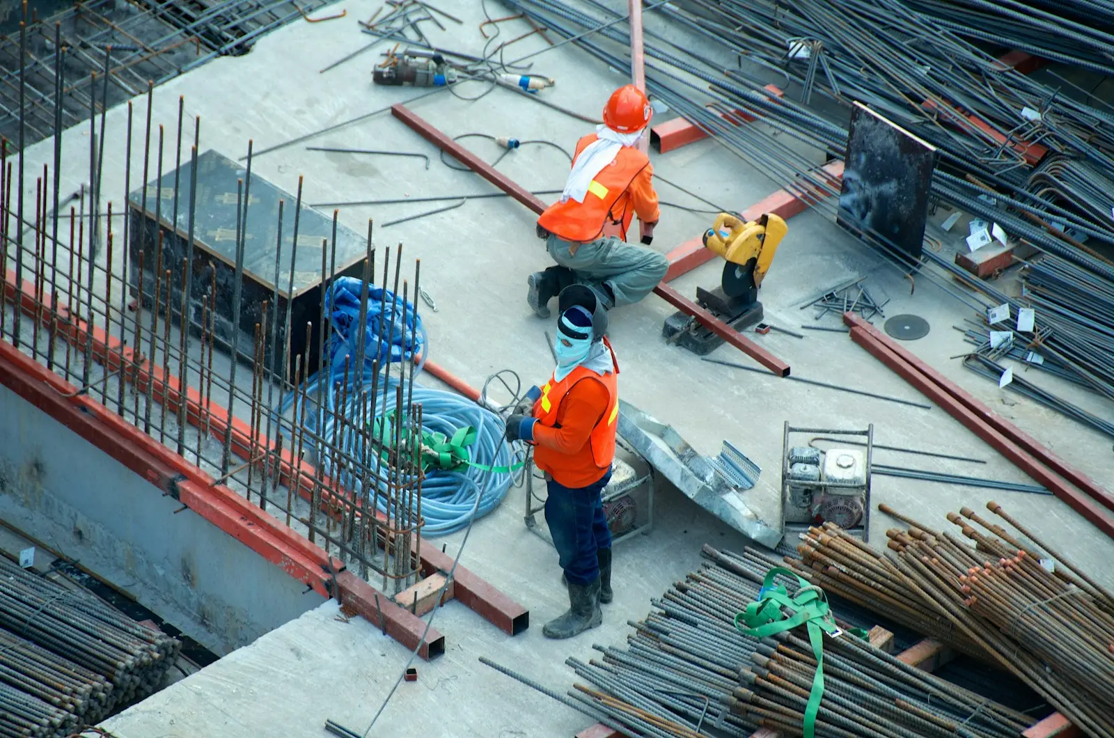 Construction workers tying steel reinforcement on a rooftop slab