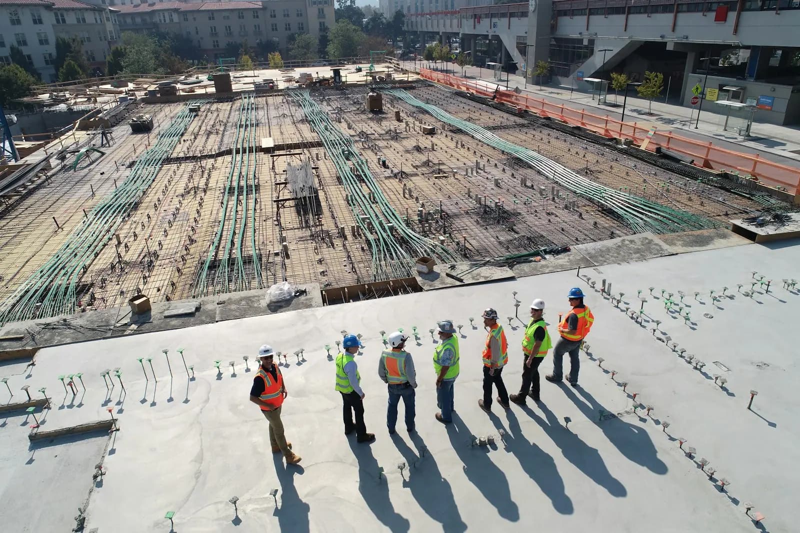 Construction crew standing on a freshly laid RCC slab with reinforcement in place